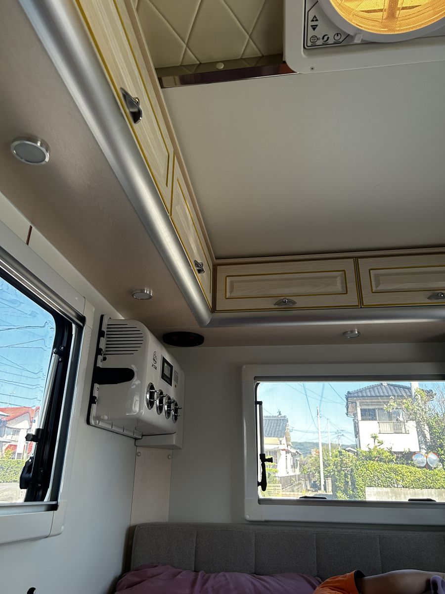 うちの軽キャンの車内。窓の上に壁掛けのエアコンがついている